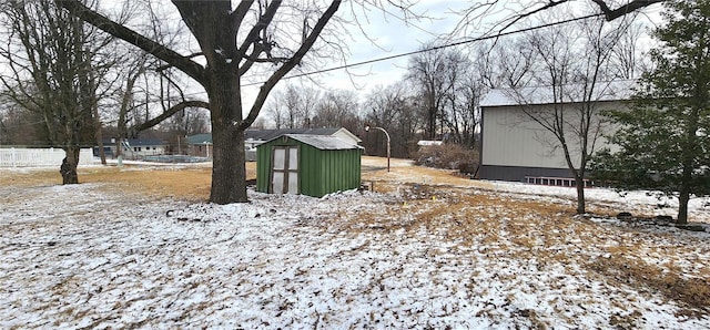 snowy yard with a storage shed