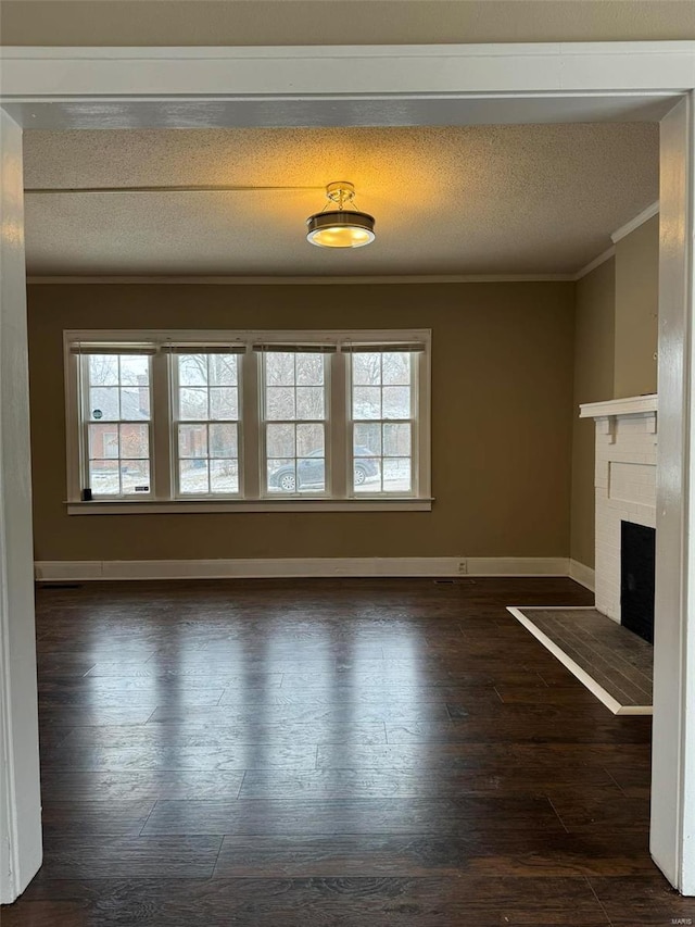 unfurnished living room with ornamental molding, dark wood-type flooring, a brick fireplace, and a wealth of natural light