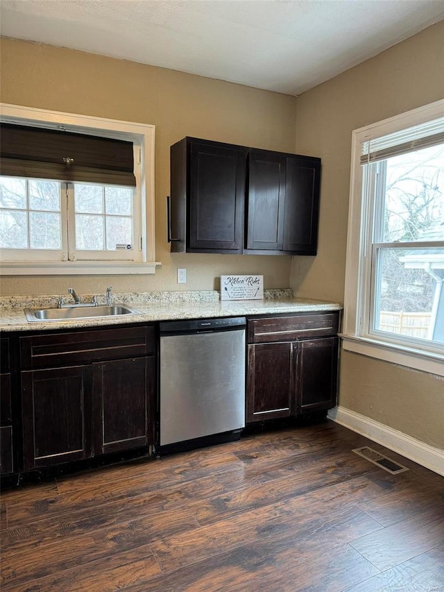 kitchen with visible vents, stainless steel dishwasher, a sink, light countertops, and dark wood-style floors