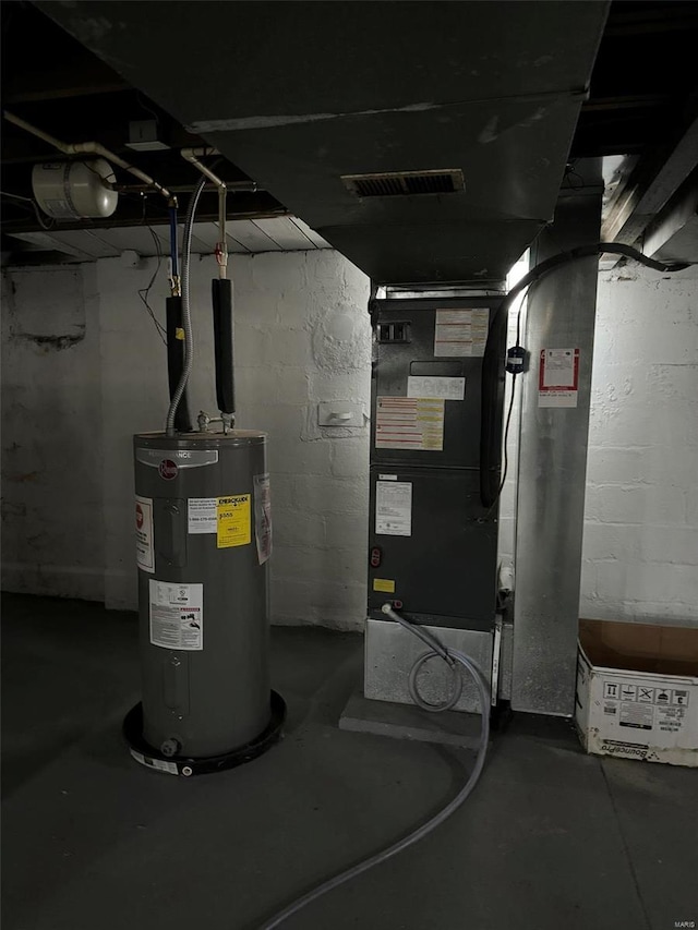 utilities with water heater, heating unit, and visible vents