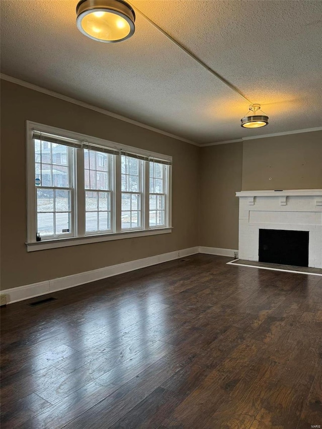 unfurnished living room with ornamental molding, a textured ceiling, dark wood-style floors, and a fireplace