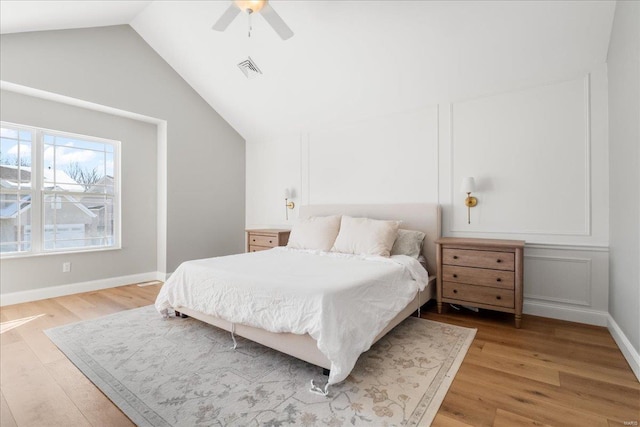 bedroom with a ceiling fan, visible vents, vaulted ceiling, baseboards, and light wood-type flooring