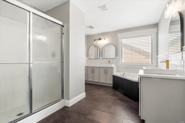 bathroom with a bath, a stall shower, visible vents, and a sink