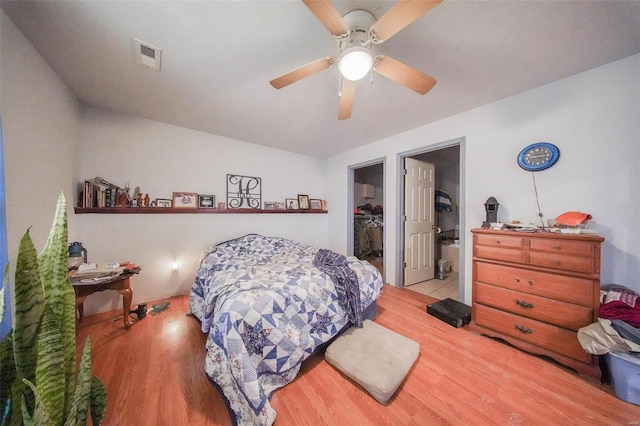 bedroom with visible vents, a spacious closet, light wood-style flooring, and a ceiling fan