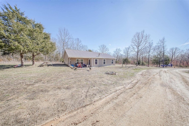 view of front of home with driveway and metal roof