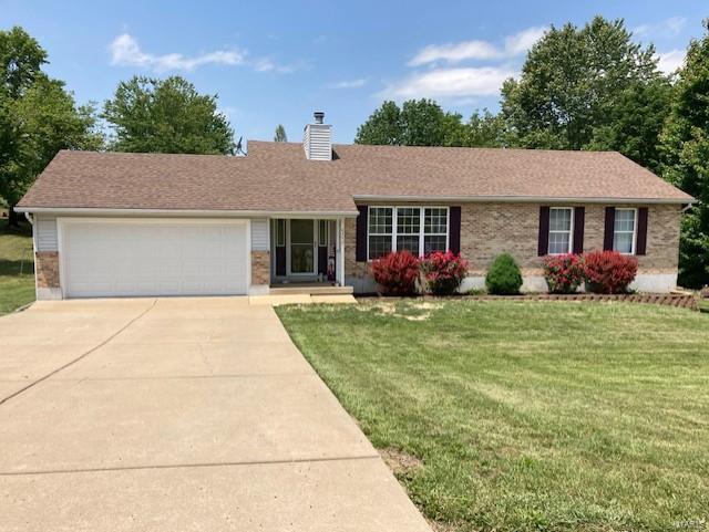 ranch-style home featuring roof with shingles, a chimney, an attached garage, driveway, and a front lawn