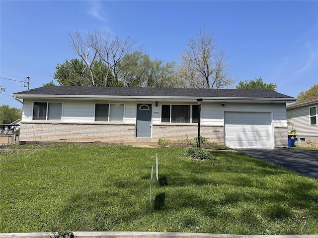 single story home featuring a garage, a front yard, and aphalt driveway