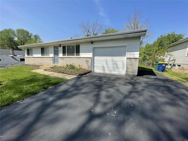 ranch-style house with a garage, driveway, and a front lawn