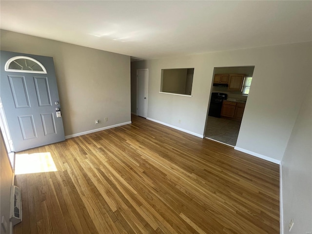 unfurnished living room with light wood-style flooring and baseboards