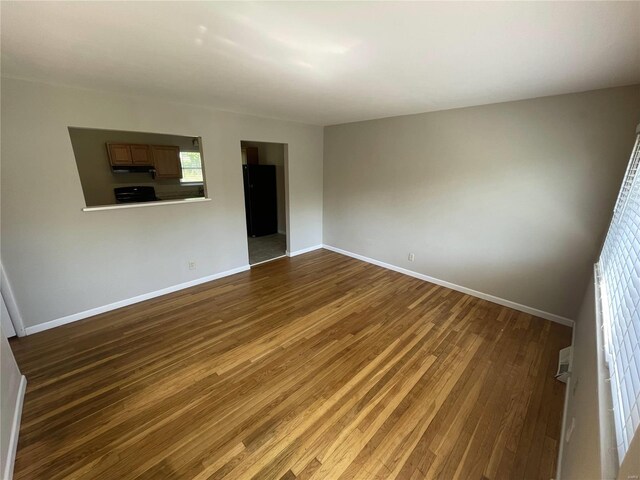 unfurnished room featuring dark wood-type flooring and baseboards