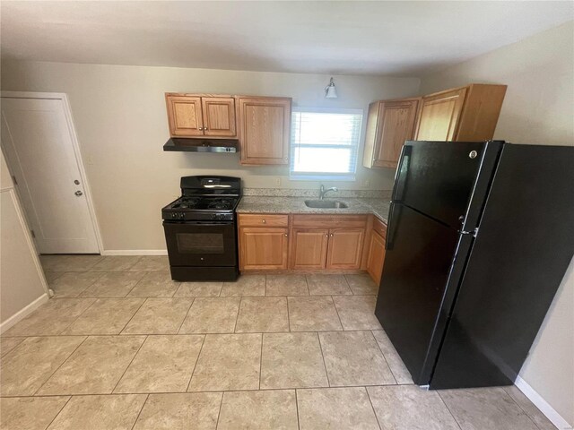 kitchen with light tile patterned flooring, under cabinet range hood, a sink, baseboards, and black appliances