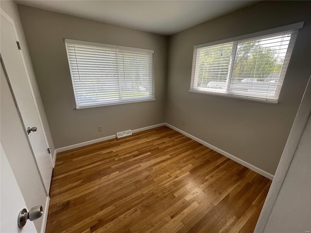 unfurnished bedroom featuring light wood finished floors, baseboards, and visible vents