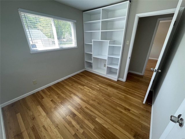 unfurnished bedroom with baseboards and wood finished floors