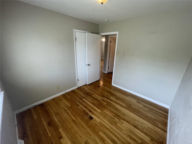 unfurnished bedroom featuring baseboards and hardwood / wood-style floors