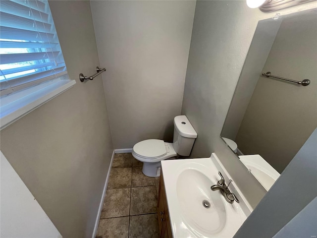 bathroom featuring toilet, tile patterned flooring, vanity, and baseboards