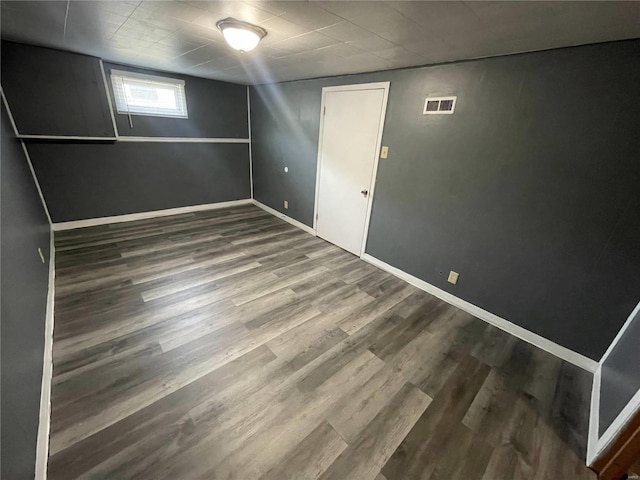 interior space featuring baseboards, visible vents, and wood finished floors