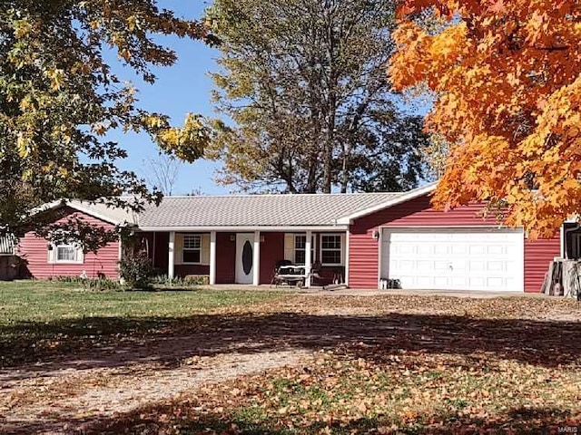 single story home featuring dirt driveway, a front lawn, and an attached garage