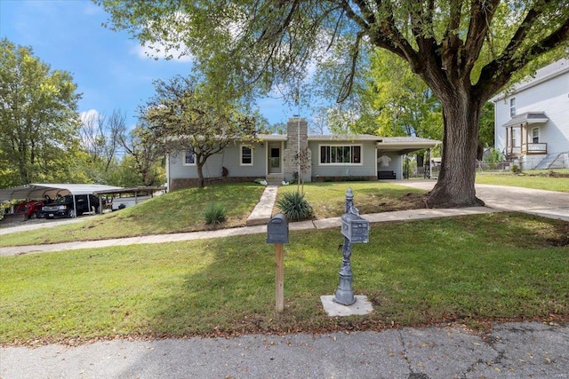 view of front of house featuring a carport and a front yard