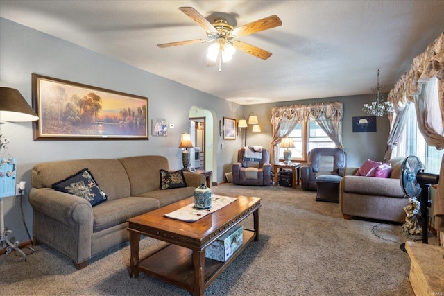 living room with ceiling fan with notable chandelier and carpet