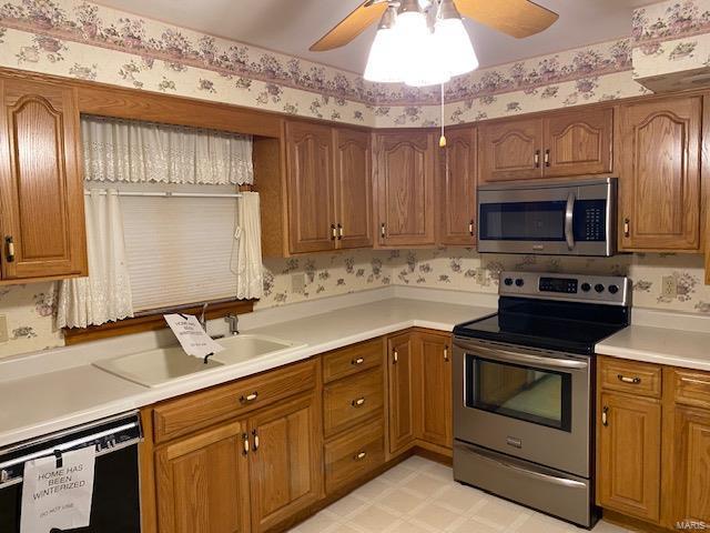 kitchen with ceiling fan, stainless steel appliances, and sink