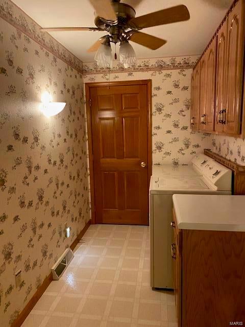 laundry room with ceiling fan, separate washer and dryer, and cabinets