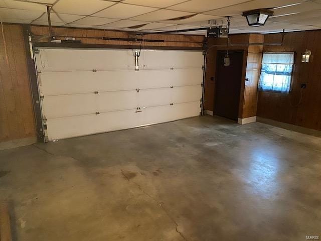 garage featuring a garage door opener and wood walls