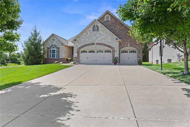 french country style house with an attached garage, driveway, brick siding, and a front yard