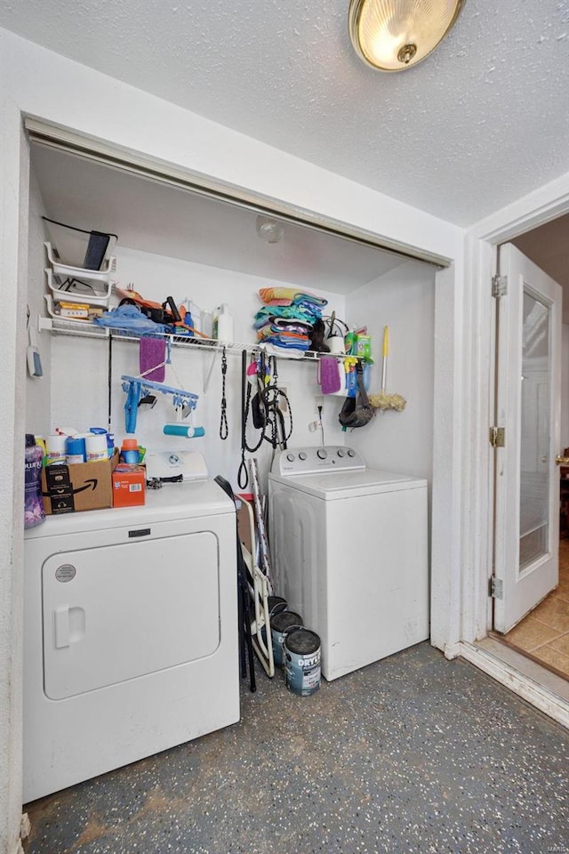 laundry room featuring laundry area, a textured ceiling, and washer and dryer