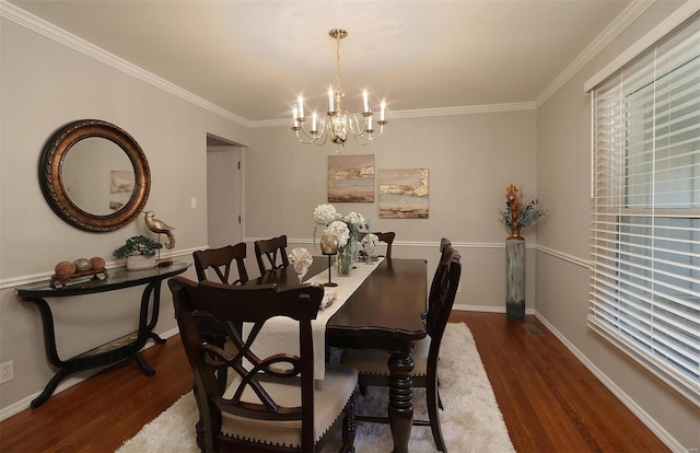 dining room featuring baseboards, an inviting chandelier, wood finished floors, and crown molding