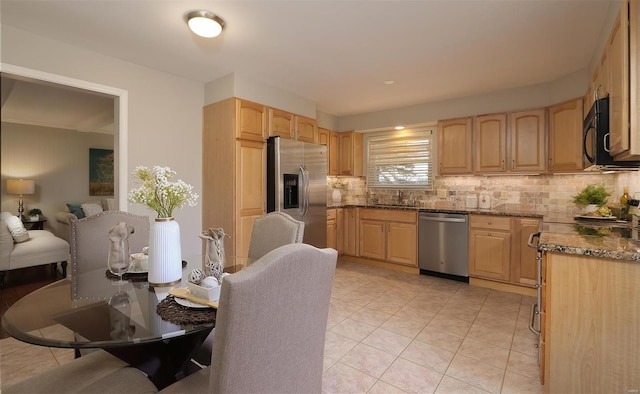 kitchen featuring a sink, stainless steel appliances, tasteful backsplash, and light brown cabinetry