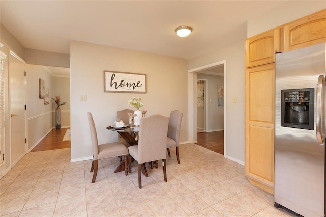 dining area featuring light tile patterned flooring and baseboards