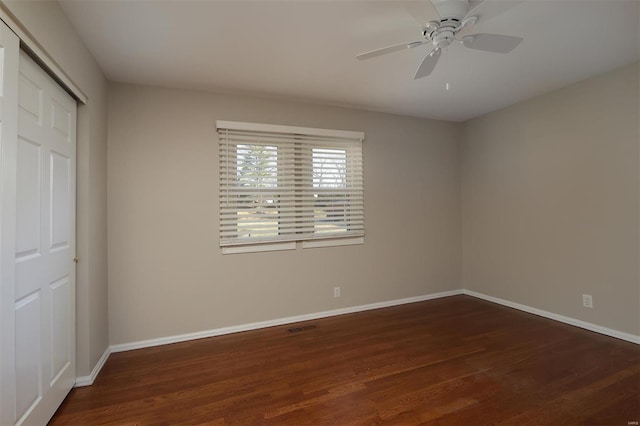 unfurnished bedroom with ceiling fan, a closet, baseboards, and wood finished floors