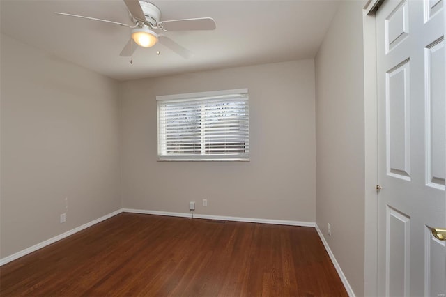 spare room featuring a ceiling fan, baseboards, and wood finished floors