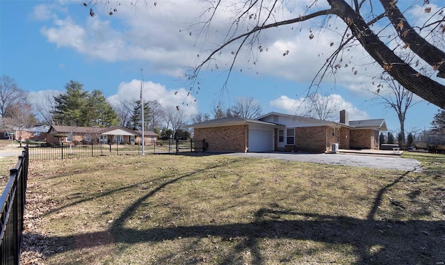 exterior space featuring fence, driveway, an attached garage, a chimney, and brick siding