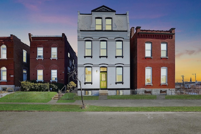 view of front facade with a yard and brick siding