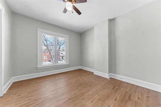 empty room with ceiling fan, light wood-type flooring, and baseboards