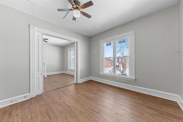 spare room featuring ceiling fan, wood finished floors, and baseboards