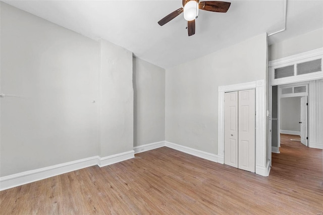 unfurnished room featuring a ceiling fan, light wood-type flooring, and baseboards