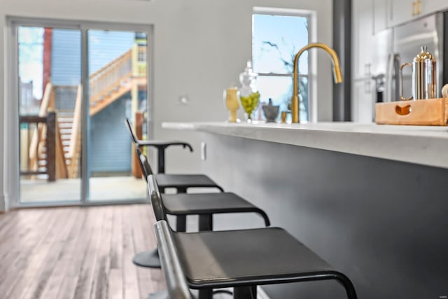 kitchen featuring light wood-type flooring, sink, and stainless steel refrigerator