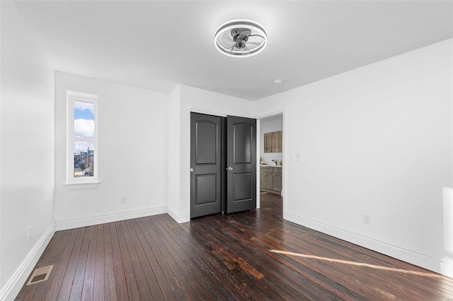 unfurnished bedroom with dark wood-type flooring