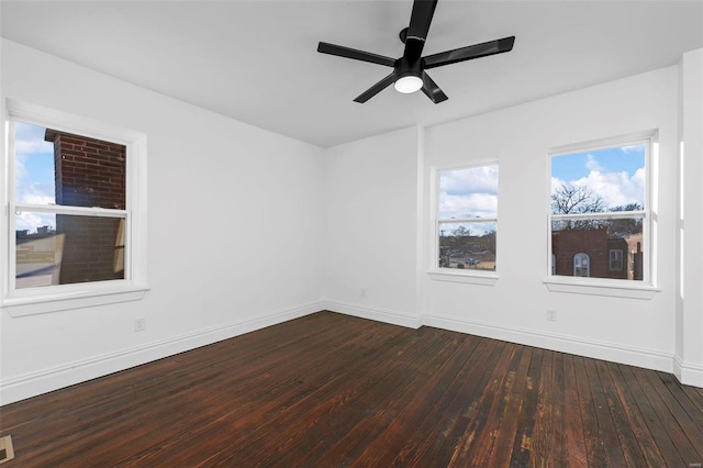 empty room with ceiling fan and dark hardwood / wood-style flooring