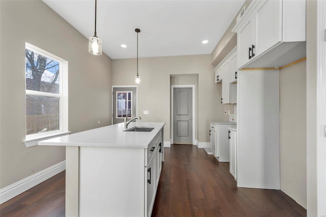 kitchen with a kitchen island with sink, decorative light fixtures, sink, white cabinets, and dark hardwood / wood-style floors