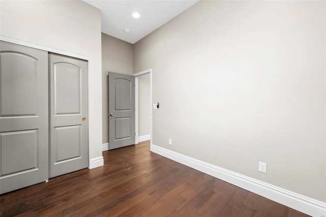 unfurnished bedroom featuring a closet and dark hardwood / wood-style flooring