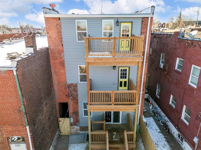 snow covered house featuring a balcony