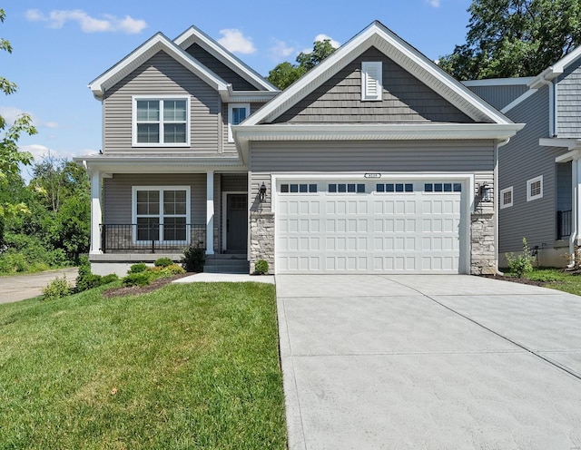 craftsman house featuring driveway, stone siding, a front lawn, and an attached garage