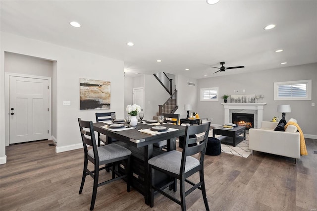 dining room featuring recessed lighting, stairway, wood finished floors, and a high end fireplace