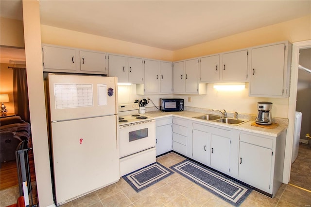 kitchen featuring white appliances, light countertops, and a sink