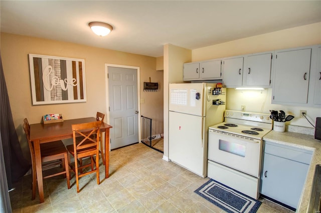 kitchen with white appliances, light countertops, and gray cabinetry