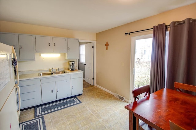 kitchen with a wealth of natural light, freestanding refrigerator, light countertops, and a sink