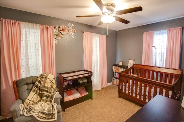 bedroom featuring light carpet, ceiling fan, and baseboards